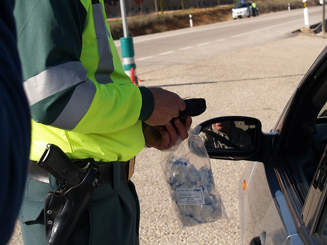 An officer standing next to a person in a car, putting the results of a test into an evidence bag.